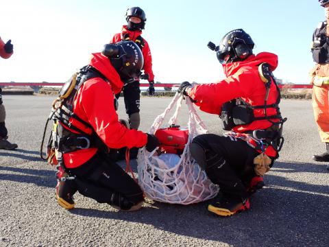 可搬式ポンプを積載する隊員です。