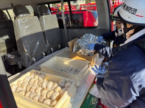 現場指揮本部で炊き出しを行う消防団員です。